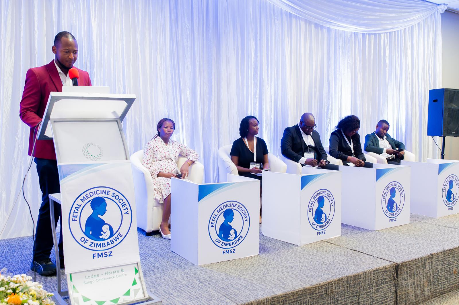 Speaker at the podium with panellists seated on stage at the Annual Congress